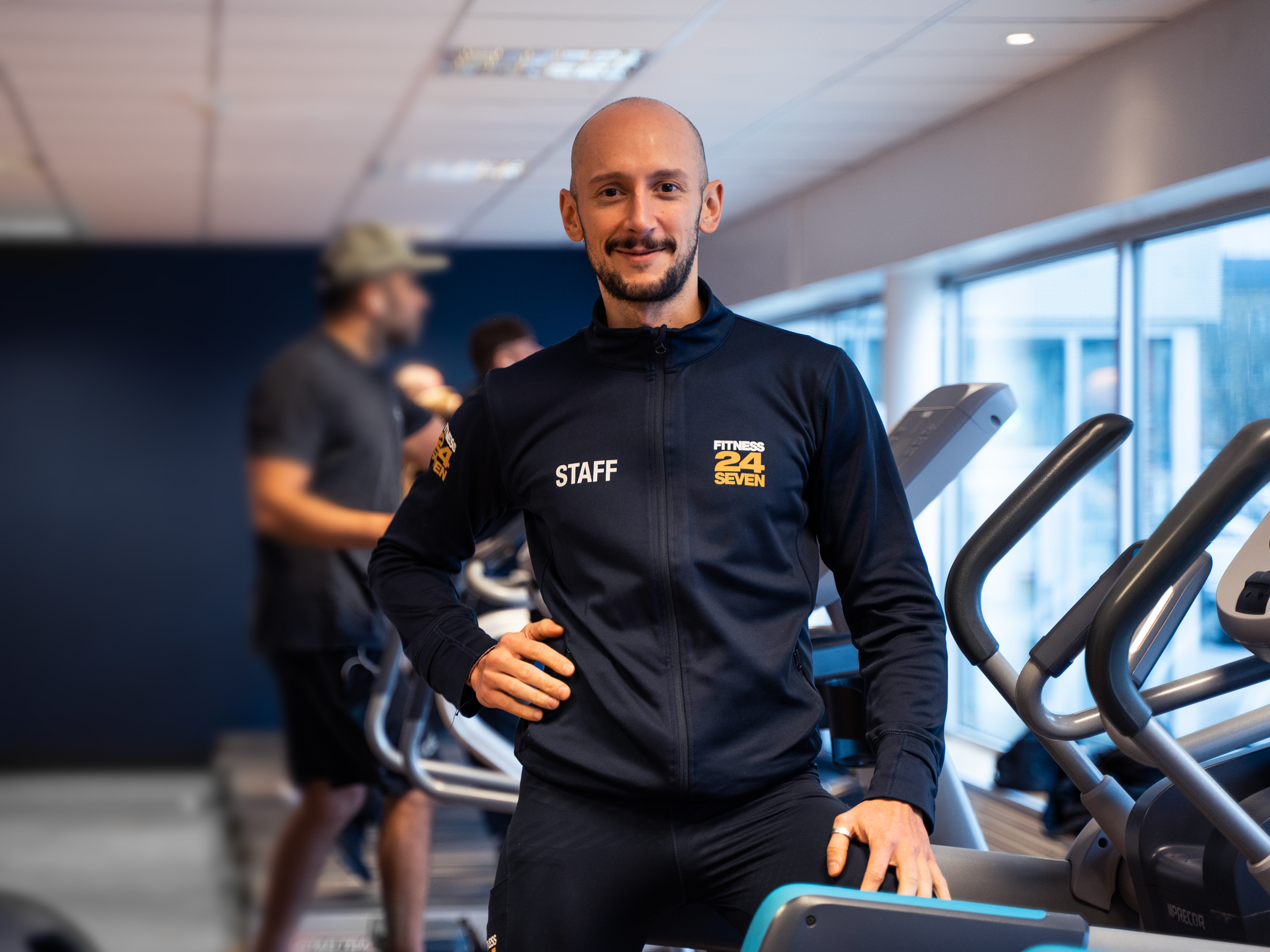 Man som jobbar på Fitness24Seven står på gymmet